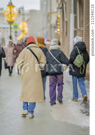 Back view of young woman walking at city street in winter. Modern city Back view of young woman walking at city street in winter. Modern city 111549118