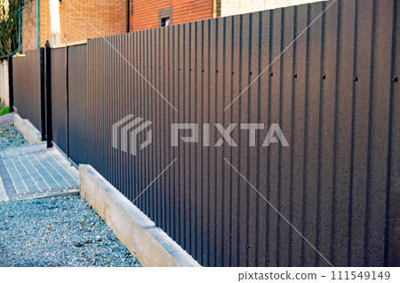 Brown fence is shown in front of brick building with arched doorway. Brown fence is shown in front of brick building with arched doorway. 111549149