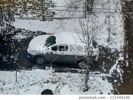 Car covered in snow is parked next to tree. 111549180