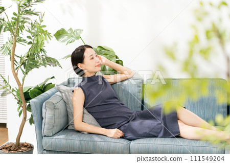 一個 30 多歲的女人躺在陽光明媚的沙發上 一個 30 多歲的女人躺在陽光明媚的沙發上 111549204