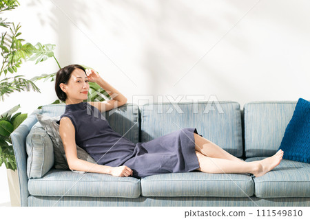A woman in her 30s lying on the sofa 111549810