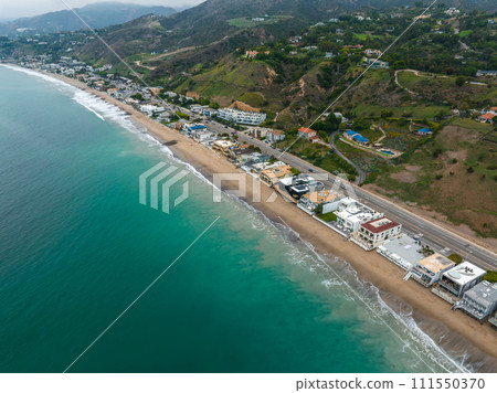 Malibu beach aerial view in California near Los Angeles, USA. Waves hitting the shore near expensive houses in Malibu. Malibu beach aerial view in California near Los Angeles, USA. Waves hitting the shore near expensive houses in Malibu. 111550370