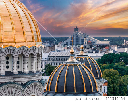 The Nativity of Christ Cathedral in Riga, Latvia. Byzantine-styled Orthodox cathedral, the largest in the Baltic region, with golden colored dome, polished gilded cupolas gleaming through the trees 111550434