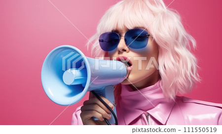 A stylish woman with pink hair shouts into a megaphone against a pink background 111550519
