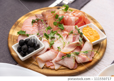 Delicious meat platter - sliced dry-cured jamon, bacon, chorizo and salami 111550717