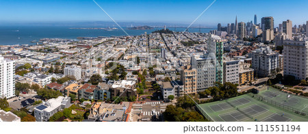 Panoramic view of aerial Lombard Street, an east west street in San Francisco, California. Famous for steep, one block section with eight hairpin turns. Tennis courts in San Francisco. 111551194