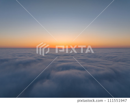 Sunset over the clouds. Aerial view of the clouds with the sunset. 111551947