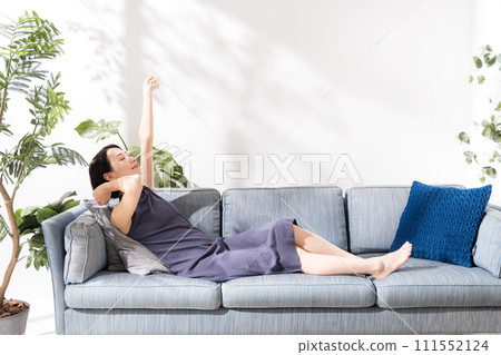 A woman in her 30s lying on the sofa A woman in her 30s lying on the sofa 111552124