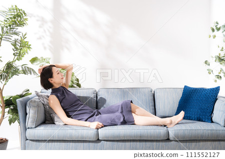 A woman in her 30s lying on the sofa A woman in her 30s lying on the sofa 111552127