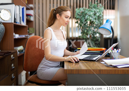 Portrait of a young sexy woman business manager working at a computer 111553035