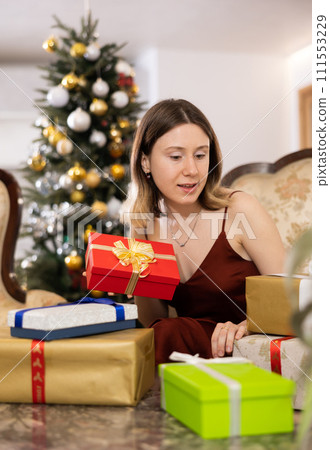 Happy young woman prepares Christmas presents 111553229