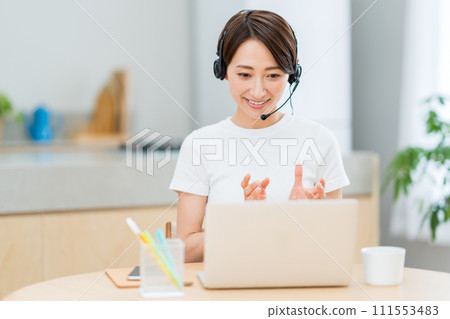 在客廳遠程辦公的中年婦女。 在客廳遠程辦公的中年婦女。 111553483