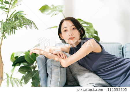 一名 30 多歲的女性在沙發上放鬆 111553595