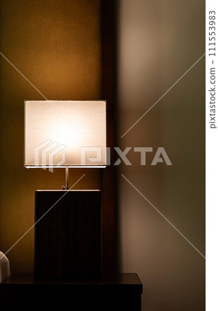 Glowing lamp on nightstand In the evening. Glowing lamp on nightstand In the evening. 111553983