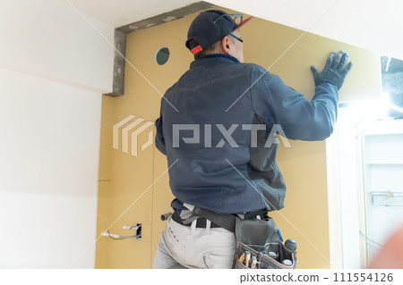 Renovation work: Craftsman installing plasterboard 111554126