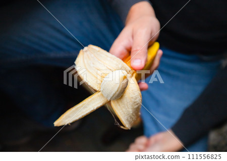 Male circumcision concept. surgical operation to dissect the frenum of the foreskin in men concept. circumcision of the foreskin, phimosis. Potency concept, impotence, male strength. Man holds banana 111556825