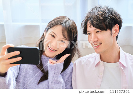 Young man and woman looking at smartphone screen Young man and woman looking at smartphone screen 111557261
