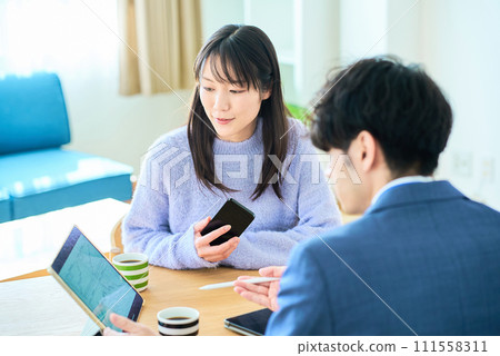Young woman listening to a man in a suit 111558311