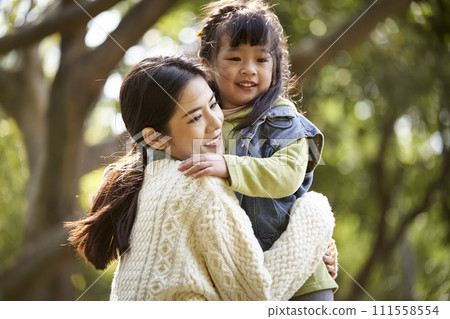 asian mother and daughter hugging outdoors 111558554