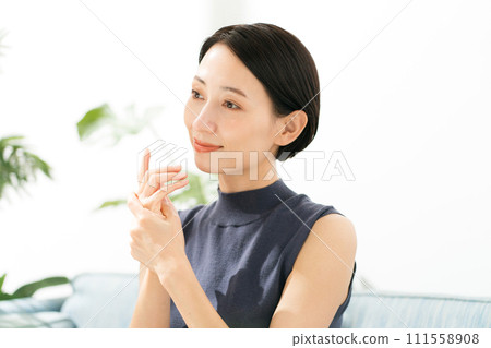 一位女士在雙手上塗抹保濕護理 111558908