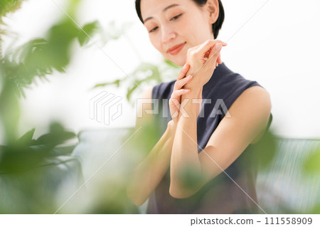 一位女士在雙手上塗抹保濕護理 111558909