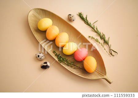 Easter eggs in pink, yellow and orange shades on a beige background. 111559333