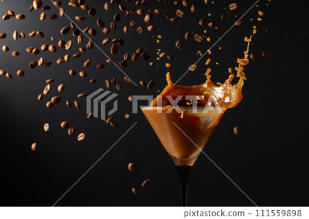 Espresso Martini drink with splashes and falling coffee beans on a black background. Espresso Martini drink with splashes and falling coffee beans on a black background. 111559898