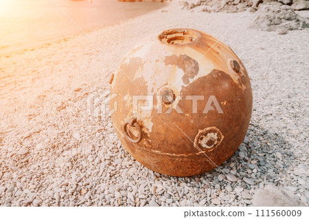 Old rusty sea mine on the beach. 111560009