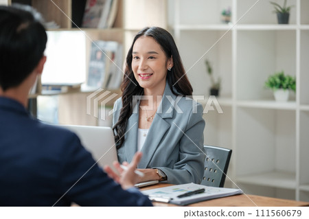 Two business workers smiling happy working sitting on desk at the office. Two business workers smiling happy working sitting on desk at the office. 111560679