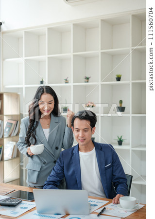 Two business workers smiling happy working sitting on desk at the office. Two business workers smiling happy working sitting on desk at the office. 111560704