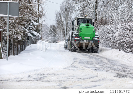 Tractor clears snow on road after heavy snowfall, road maintenance in winter season 111561772