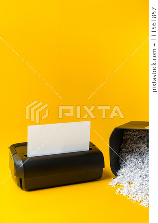 Office paper shredder on yellow studio background Office paper shredder on yellow studio background 111561857