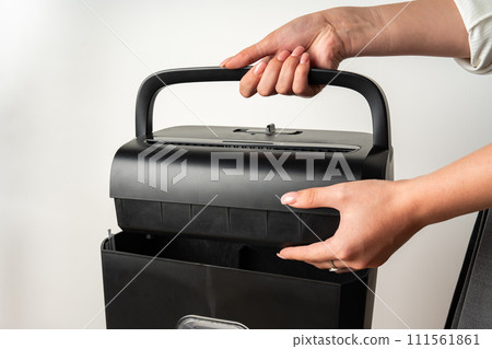 Black paper shredder cutting paper on gray background 111561861