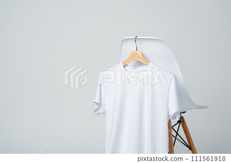 White blank t-shirt hanging on chair in empty room 111561918
