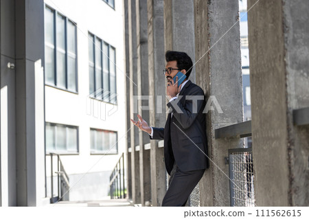 Stylish young businessman in office area with a phone in hands 111562615