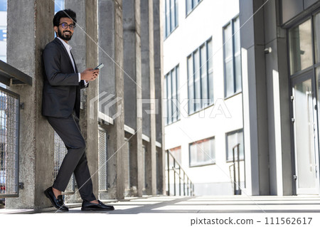 Stylish young businessman in office area with a phone in hands 111562617