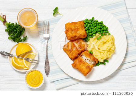 fried fish with mashed potatoes and green peas 111563020