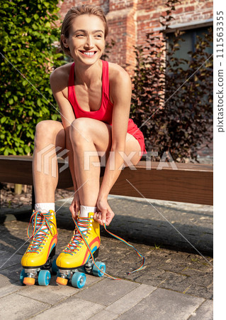 Woman tying shoelaces on rollerblades Woman tying shoelaces on rollerblades 111563355