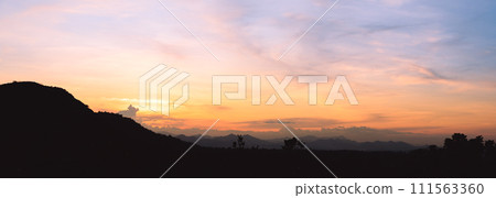 Evening time of panorama mountain under dramatic twilight sky and cloud. Nightfall Silhouette mountain on sunset. Evening time of panorama mountain under dramatic twilight sky and cloud. Nightfall Silhouette mountain on sunset. 111563360