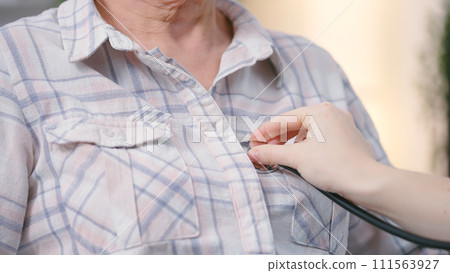 Close-up of woman physician using stethoscope to listen to patient's breath and heartbeat 111563927