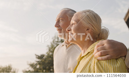 Smiling aged couple hugging outdoors, enjoying city view at sunset, family love 111564030