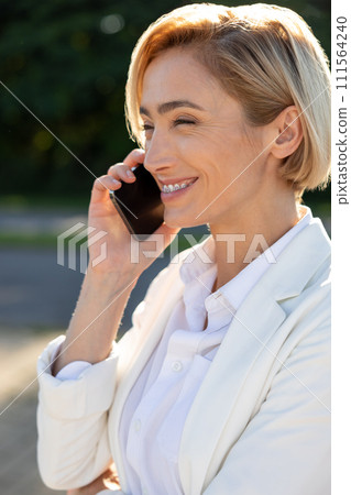 Beautiful Caucasian woman smiling confident talking on the smartphone at street 111564240