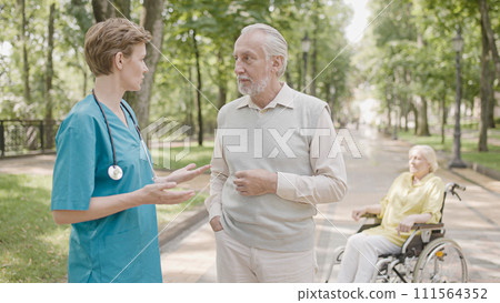 Man talking to doctor about wife's health, medical care, clinic rehabilitation Man talking to doctor about wife's health, medical care, clinic rehabilitation 111564352
