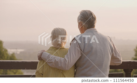 Happy senior couple enjoying sunset view together, loving husband hugging wife Happy senior couple enjoying sunset view together, loving husband hugging wife 111564450