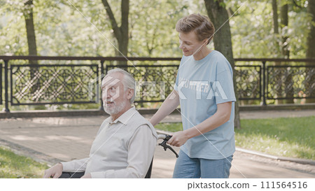 Woman volunteer taking care of elderly man with disability at retirement home, kindness Woman volunteer taking care of elderly man with disability at retirement home, kindness 111564516