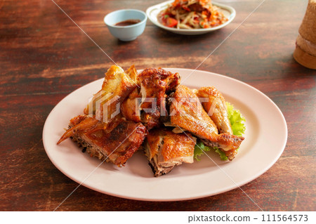 Thai grilled chicken on wooden table 111564573