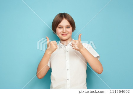Smiling cheerful child showing thumbs up 111564602