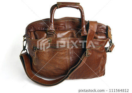 brown vintage bag made of hand-made vegetable leather with handles and strap isolated on a white background brown vintage bag made of hand-made vegetable leather with handles and strap isolated on a white background 111564812