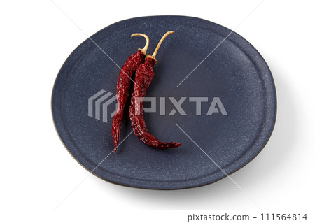 dried red hot capsicums on a gray ceramic plate. two peppers isolated on white background 111564814