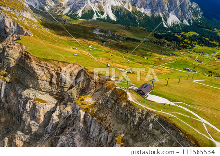 Seceda rock cliff with green grass and hiking trails. Seceda rock cliff with green grass and hiking trails. 111565534
